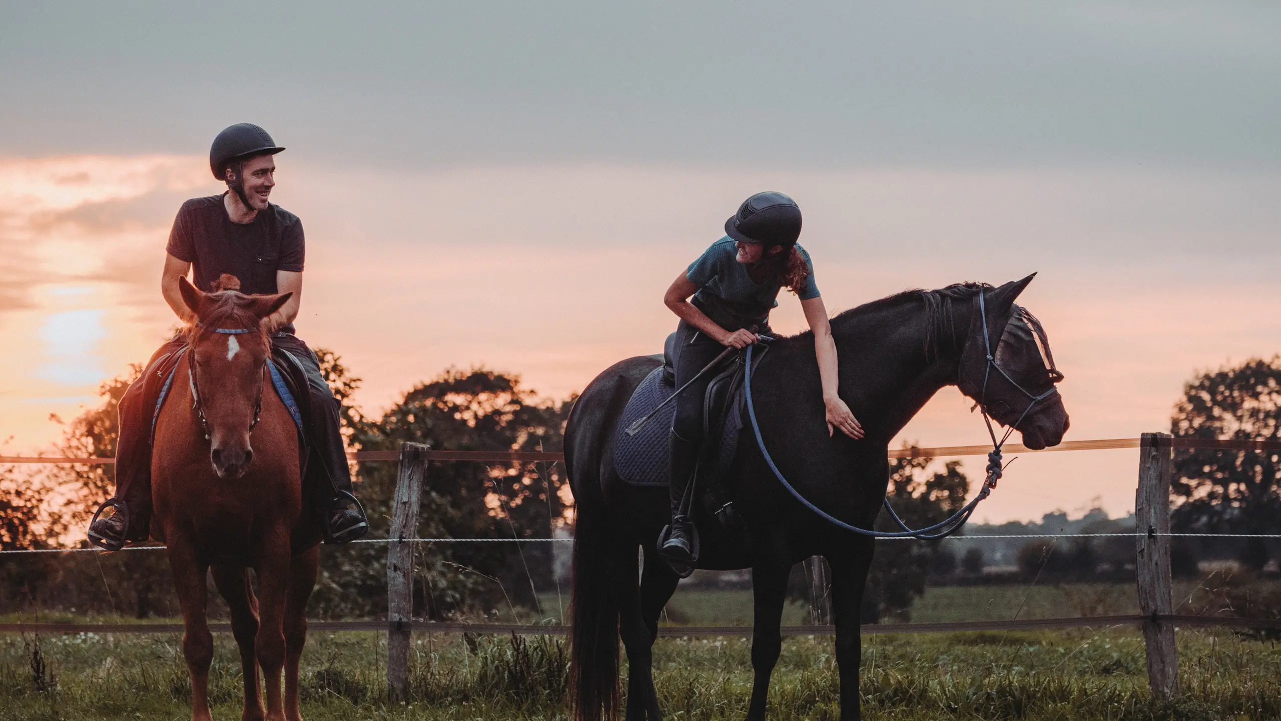 Johanna et David a cheval au coucher du soleil dans les pres de l'Ecurie Moulagny, a Planquery dans le Calvados